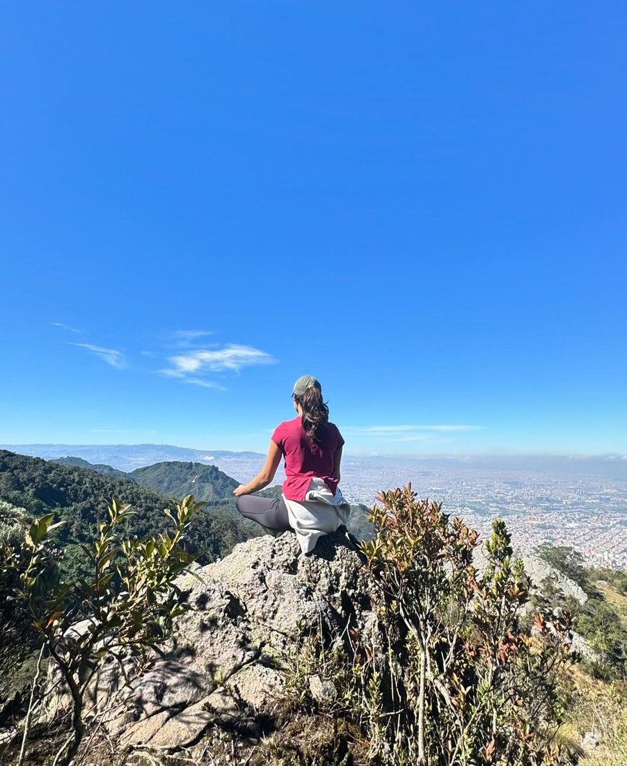 Persona meditando en mirador con vista a Bogotá